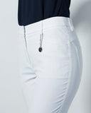 White pants with a navy top on a light gray background