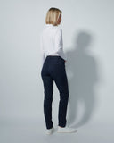 Person wearing a white shirt and dark navy pants against a plain background