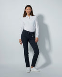 Woman wearing a white shirt and dark pants on a light gray background