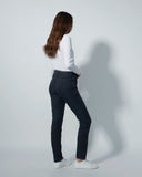 Person wearing a white shirt and dark pants against a plain background