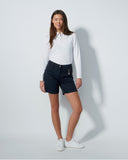 Woman wearing a white shirt and dark shorts on a light gray background