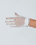 White glove on a person's hand against a light gray background