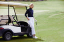 Woman standing next to a golf cart on a golf course