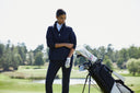 Woman on a golf course with a golf bag and clubs