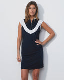 Woman wearing a navy dress with white accents against a light gray background