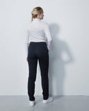 Person wearing a white shirt and dark pants against a plain white background