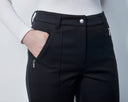 Person wearing black pants with zippers on a plain background