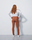 Person wearing a white long-sleeve shirt and brown pants against a white background