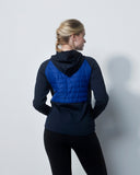 Person wearing a black jacket with a blue quilted back panel on a white background