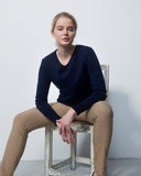 Woman sitting on a chair against a plain white background