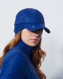 Person wearing a blue cap and jacket against a light gray background