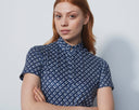 Woman wearing a blue patterned shirt against a white background