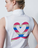 Person wearing a white sleeveless shirt with a colorful heart design on the back against a plain background