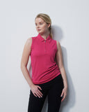 Woman wearing a pink sleeveless shirt and black pants against a white background