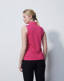 Woman wearing a pink sleeveless top and black pants against a white background