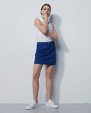 Person wearing a white top and blue skirt against a plain white background