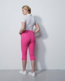 Woman wearing pink pants and a white shirt against a plain background
