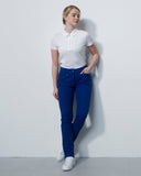 Person wearing a white polo shirt and blue pants against a plain white background