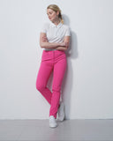 Woman wearing a white shirt and pink pants against a white background