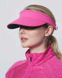 Woman wearing a pink visor and jacket against a white background