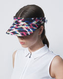 Woman wearing a colorful visor against a plain background