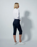 Person wearing a white shirt and navy pants against a plain background