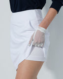 Person wearing a white skirt and transparent gloves on a plain background